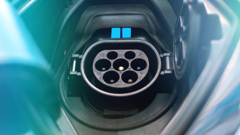 Toma de carga de un coche eléctrico con luz azul.
