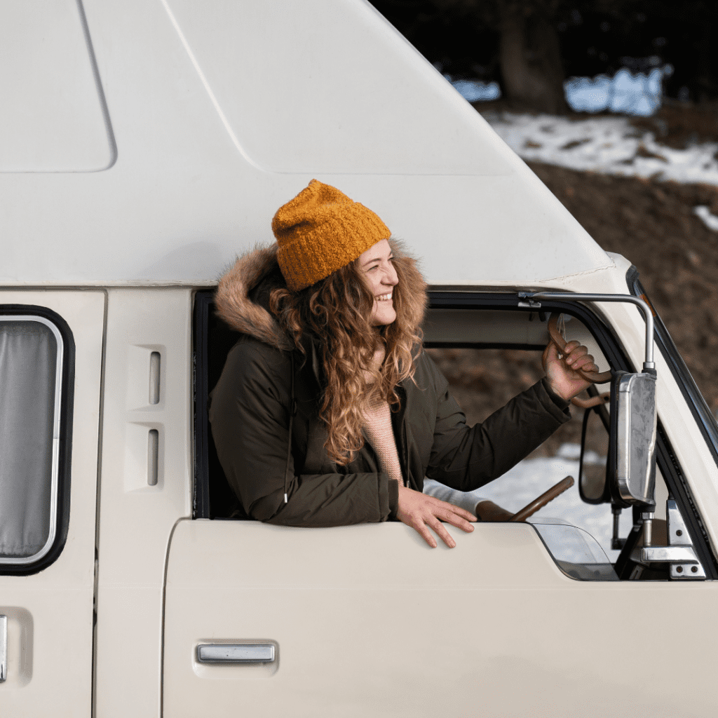En la imagen se observa una mujer sonriendo, por la ventana de un camión