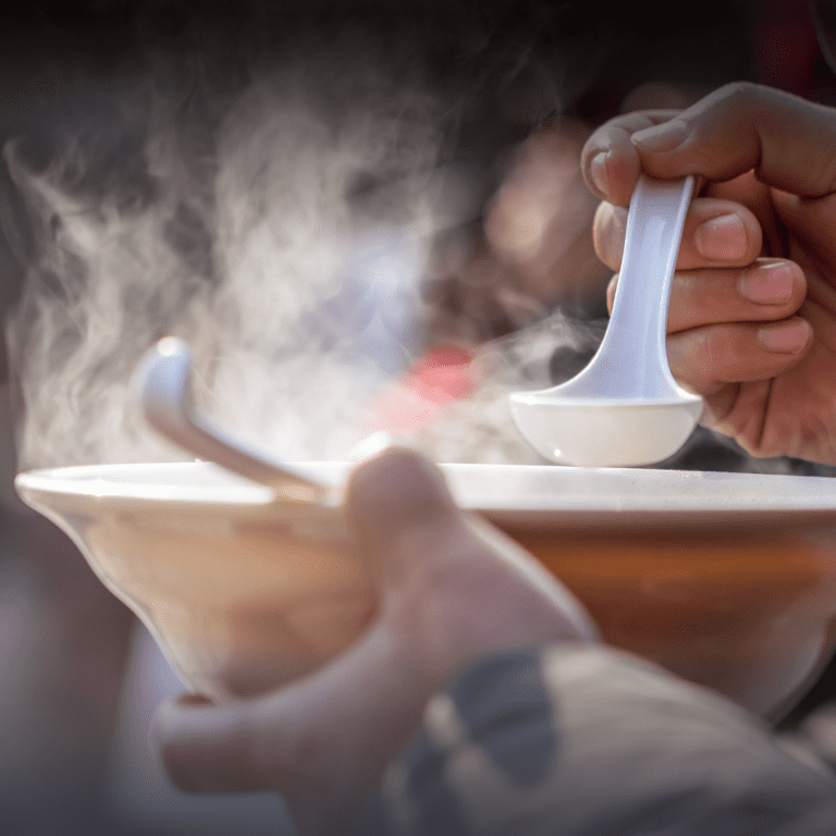 En la imagen se muestran unas manos sosteniendo un plato de sopa caliente