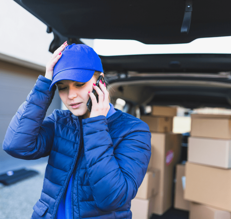 En la imagen se muestra una mujer preocupada frente a un camión con cargamento