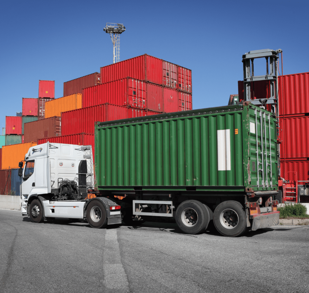 En la imagen se muestran contenedores de cargamento y un camión