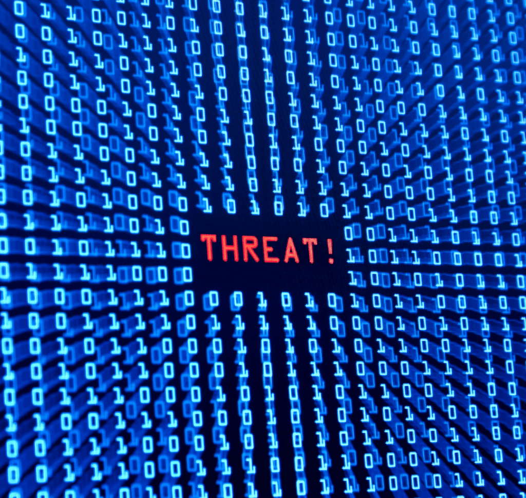 En la imagen se representa un ciberataque, con la palabra "Amenaza" en una pantalla