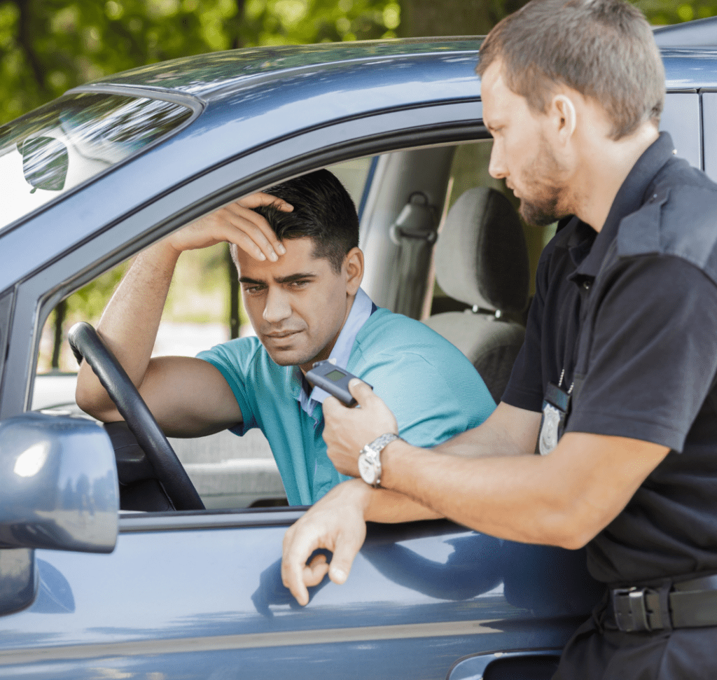 En la imagen se muestra un conductor siendo detenido por un policía