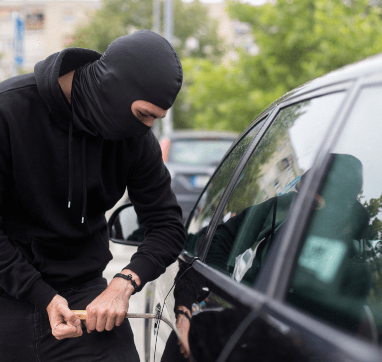 En la imagen se muestra un hombre intentando abrir un vehículo
