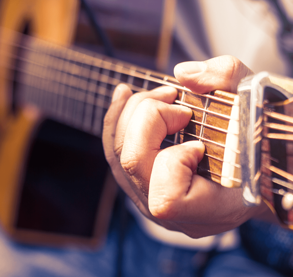 En la imagen se muestran unas manos tocando la guitarra