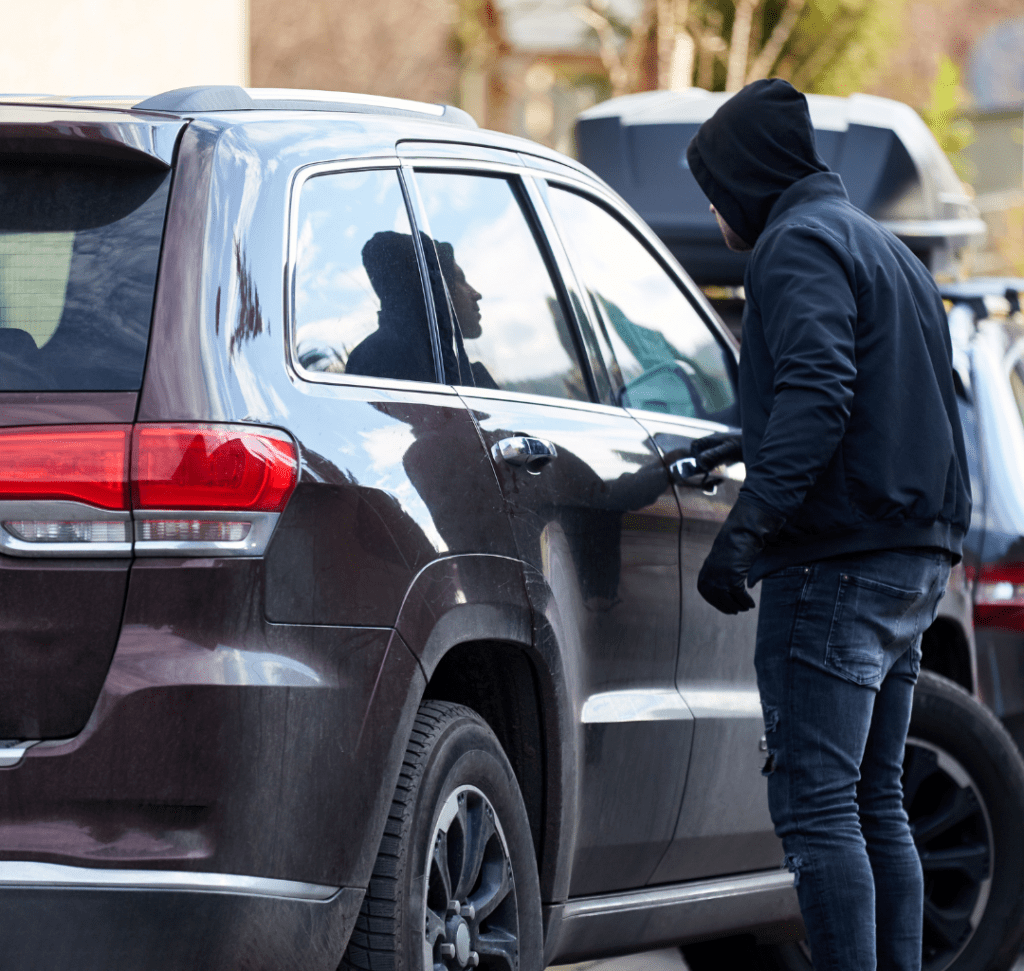 En la imagen se muestra un hombre intentando abrir un vehículo