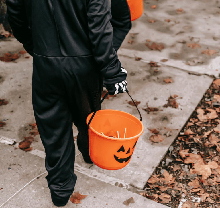 En la imagen se muestra un niño con una calabaza con dulces