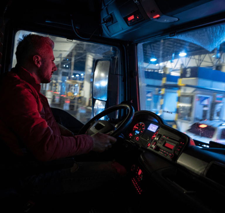 En la imagen se muestra un camionero conduciendo de noche