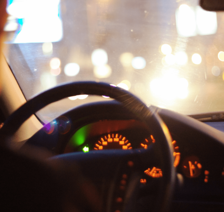 En la imagen se muestra un camionero conduciendo de noche