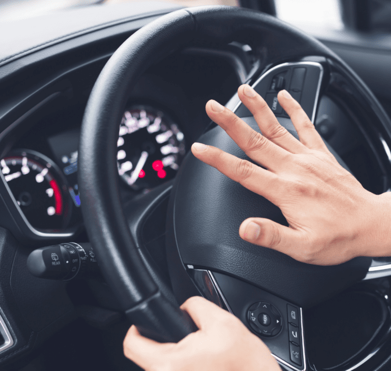 En la imagen se muestra alguien pitando el claxon