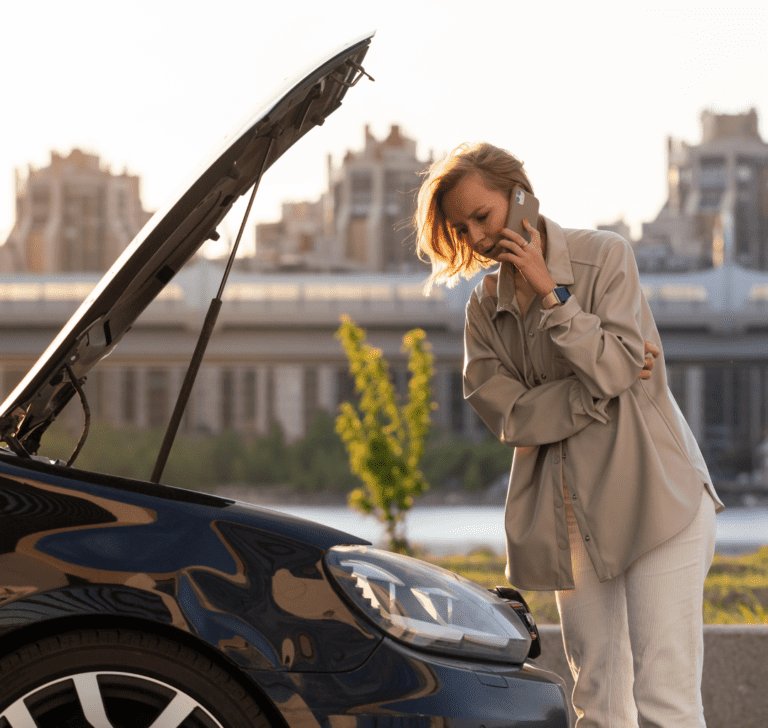 En la imagen se muestra una mujer con una falla en su vehículo