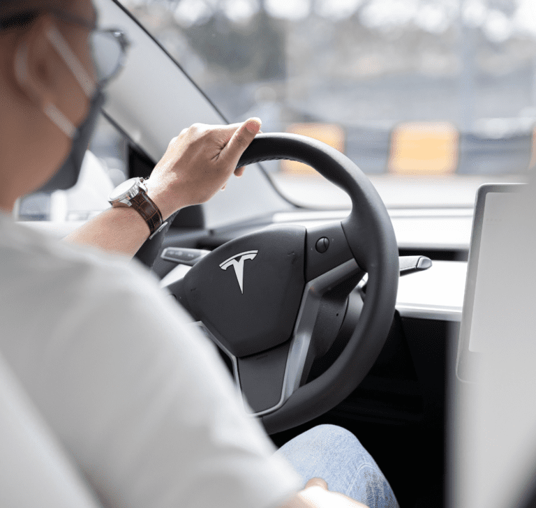 En la imagen se muestra una persona conduciendo un Tesla