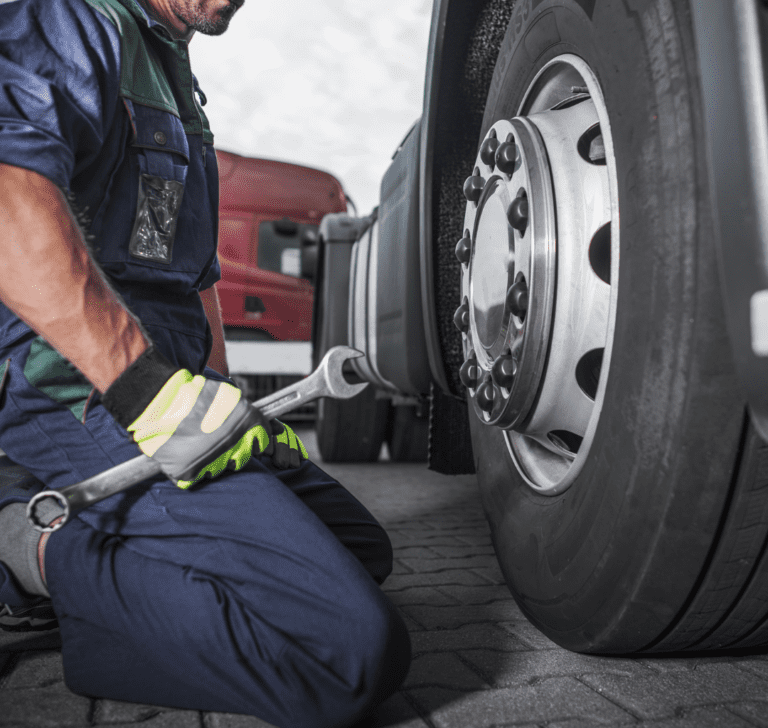 En la imagen se muestra un camionero revisando un camión