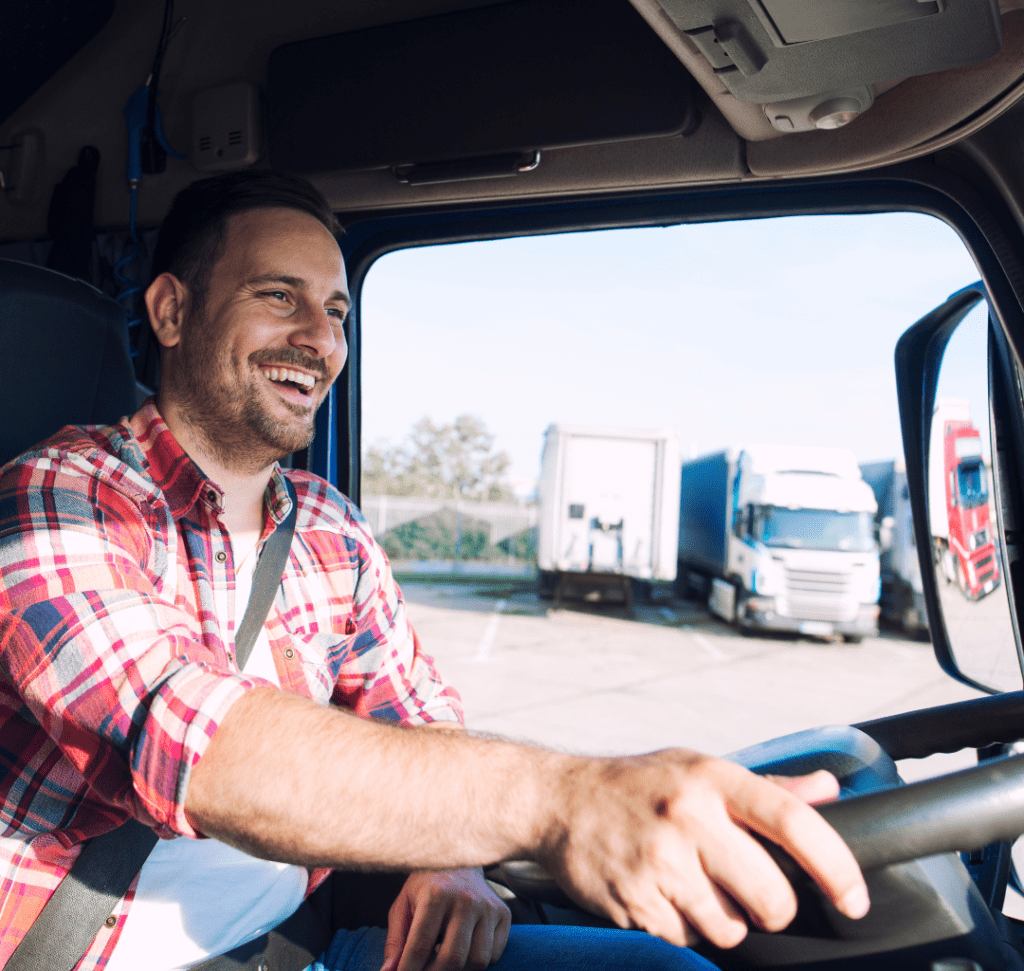 En la imagen se muestra un conductor de camión sonriendo