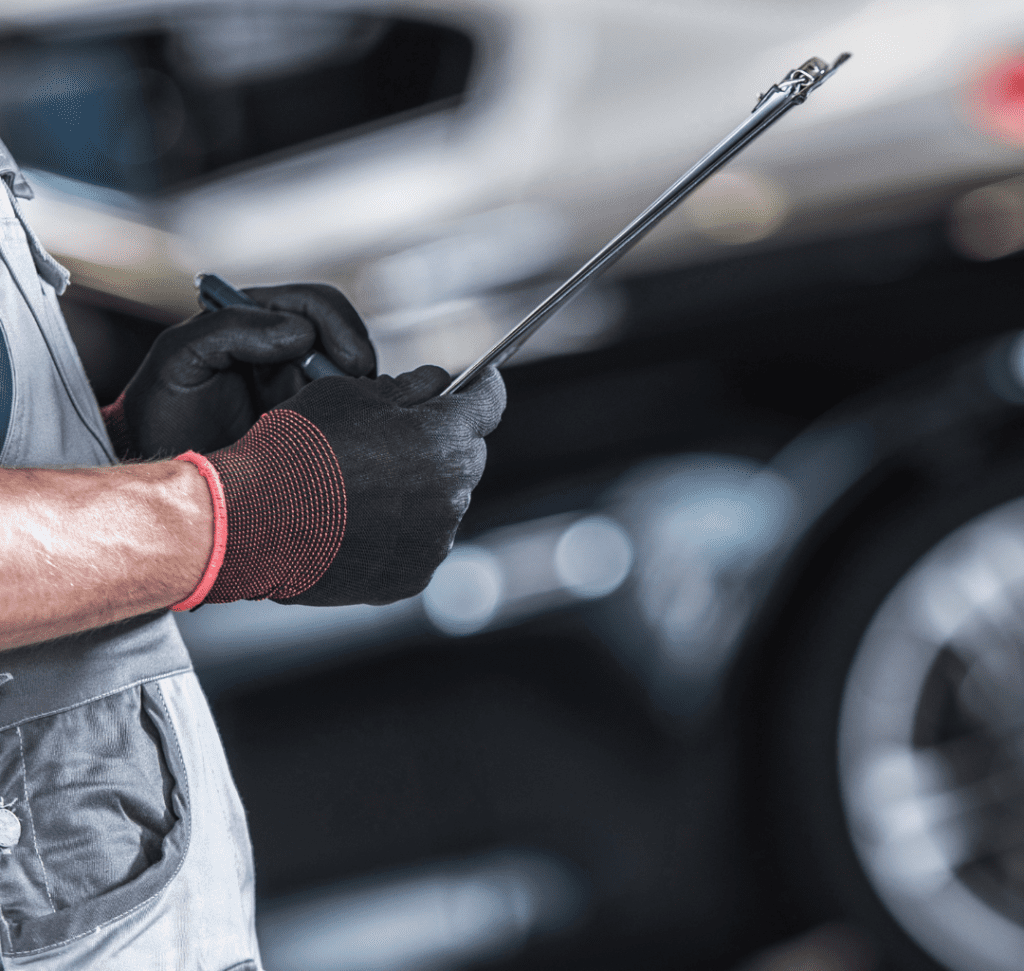 En la imagen se muestra un camionero inspeccionando un camión