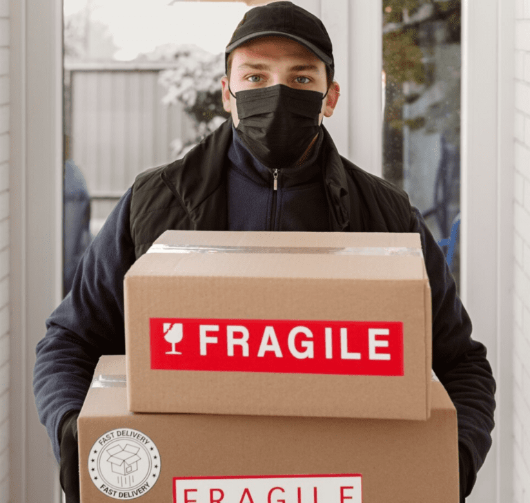 En la imagen se muestra un hombre con cajas de mercancía